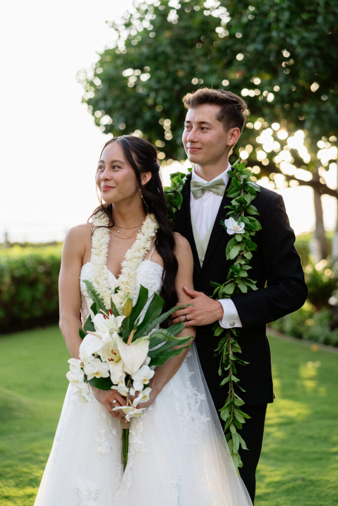 Newlyweds embracing during golden hour in Waikīkī.